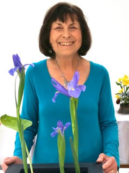 Woman in a blue shirt with purple flowers smiling