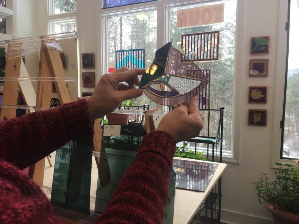Woman holding up a piece of stained glass