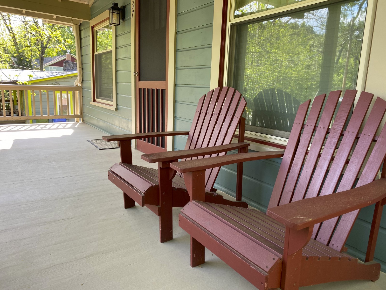 Red Adirondack chairs on front porch