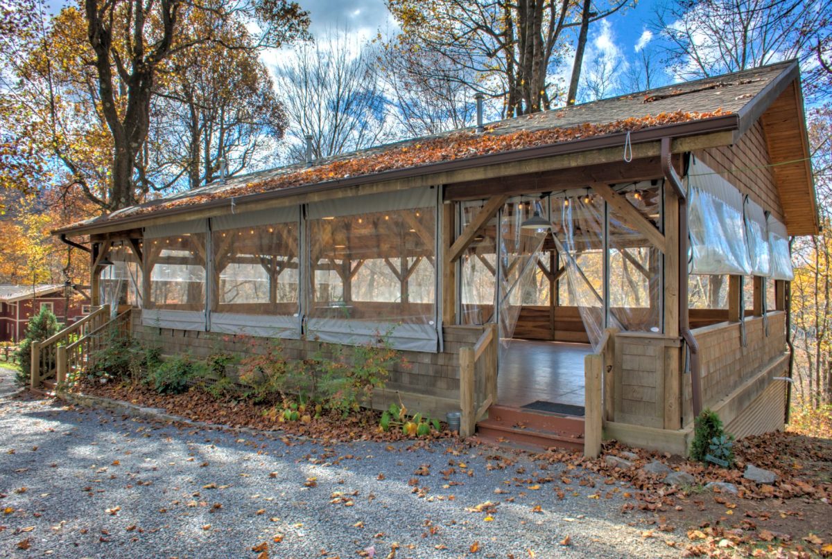 A wood pavillion under blue skies in the fall