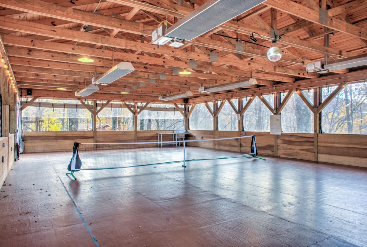 A pickleball court inside a wood pavilion
