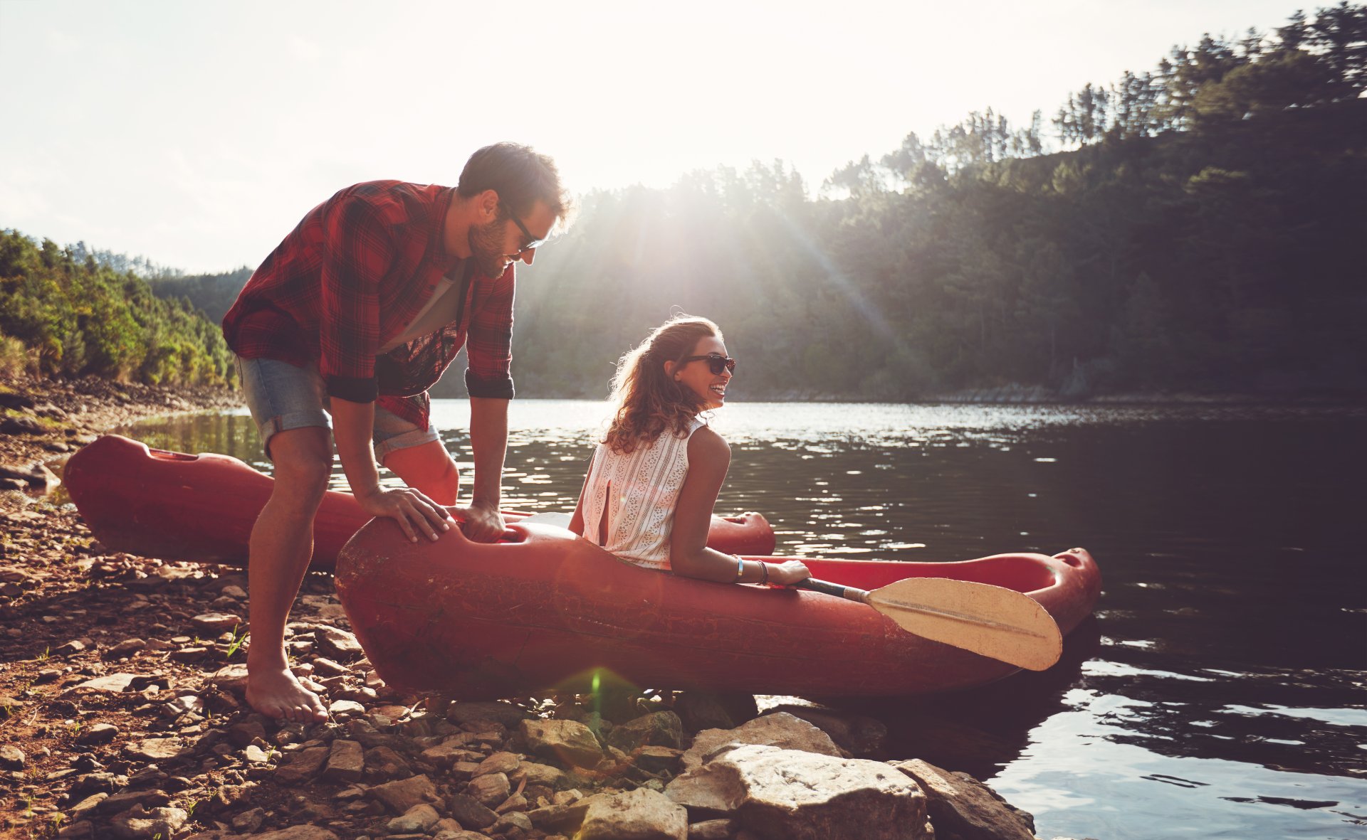 couple putting kayak into water
