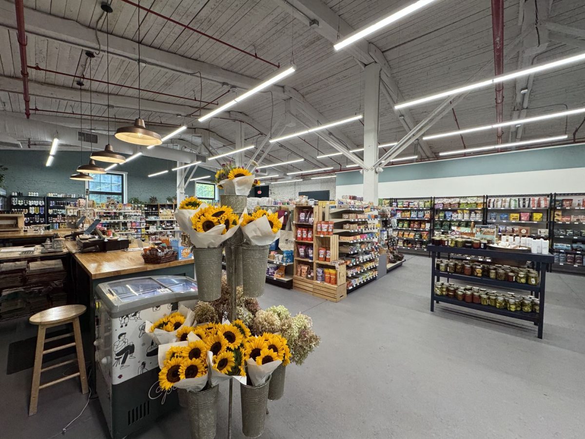 Ecusta Market interior near the Ecusta Trail in Hendersonville, NC, showing fresh flowers, local produce, and a wide selection of specialty foods in a renovated warehouse space.