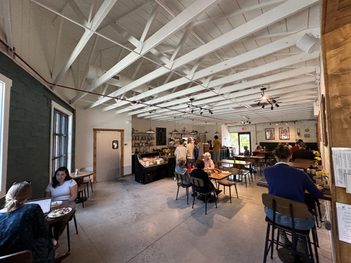 Busy interior of Ecusta Café near the Ecusta Trail, showing customers ordering at the counter, dining at tables, and enjoying the bright, open space with exposed beams.