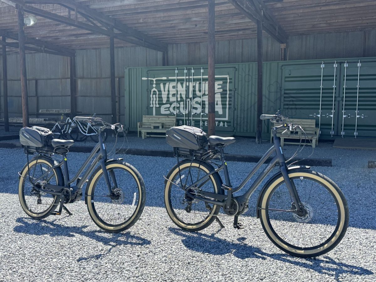 Electric bikes ready for rent at Venture Ecusta Bike Rental along the Ecusta Trail in Hendersonville, North Carolina, with the branded storage container behind them.
