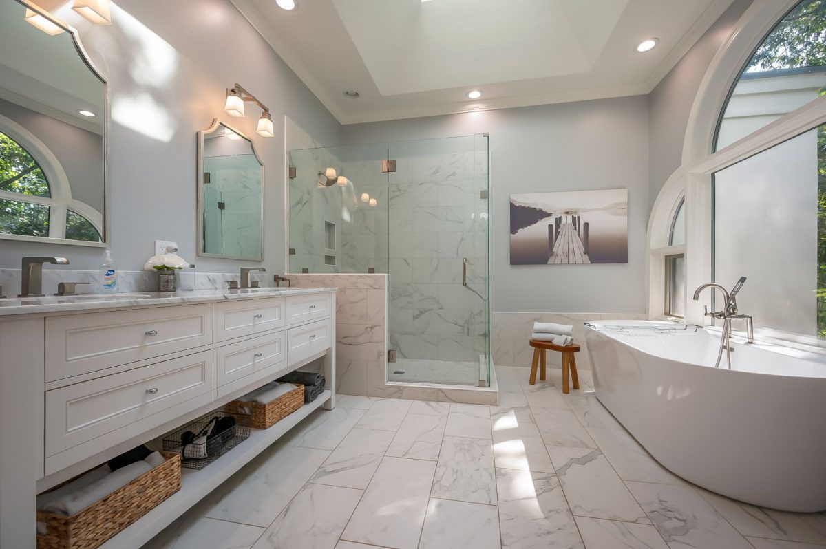 Professionally cleaned, guest-ready vacation rental bathroom with double vanity, glass-enclosed shower, soaking tub, and fresh towels prepared before check-in.