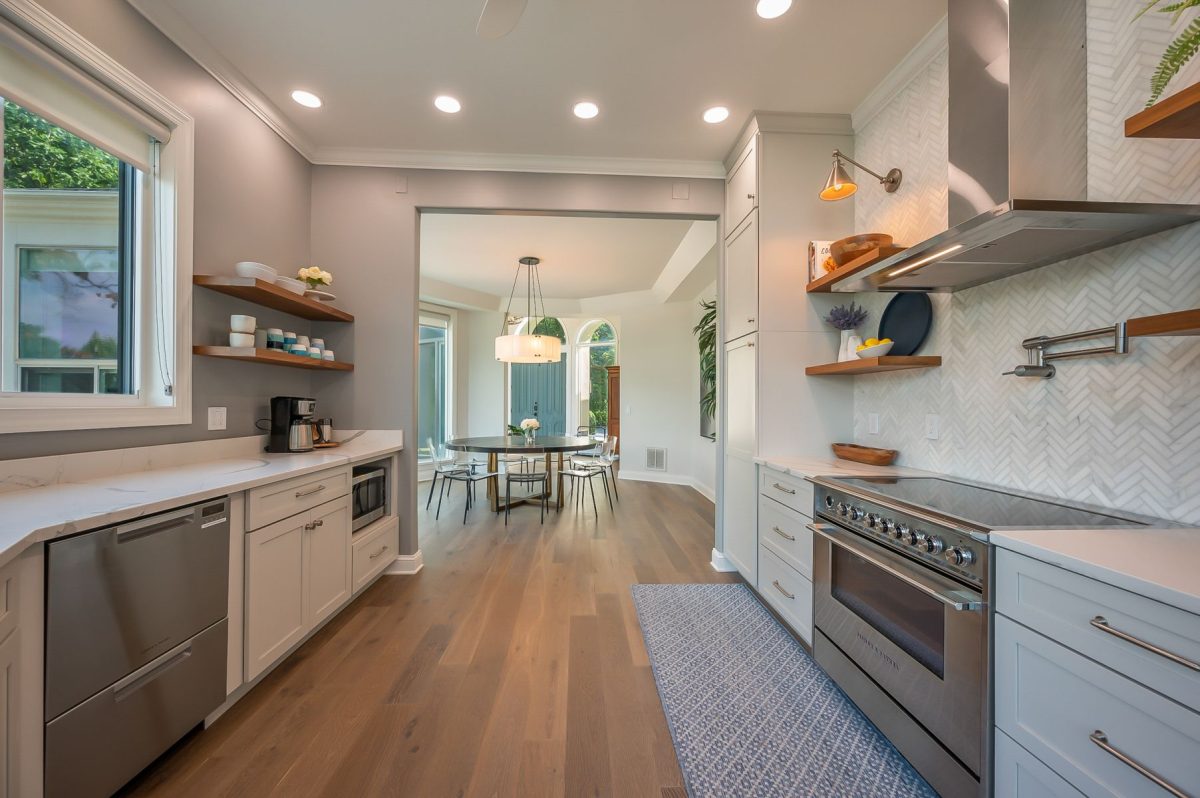 Professionally cleaned, guest-ready vacation rental kitchen with stainless steel appliances, open shelving, and hardwood floors, prepared before check-in.