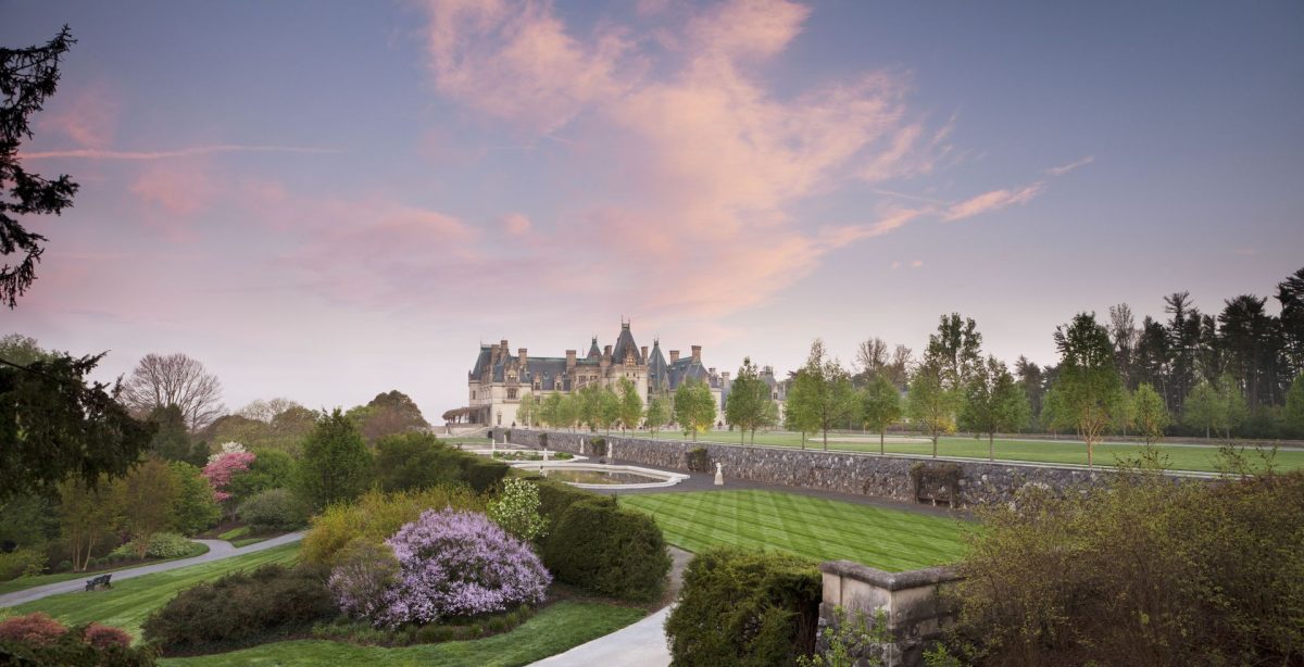 Sunset view of Biltmore Estate featuring the historic mansion, formal gardens, and landscaped grounds in Asheville, North Carolina.