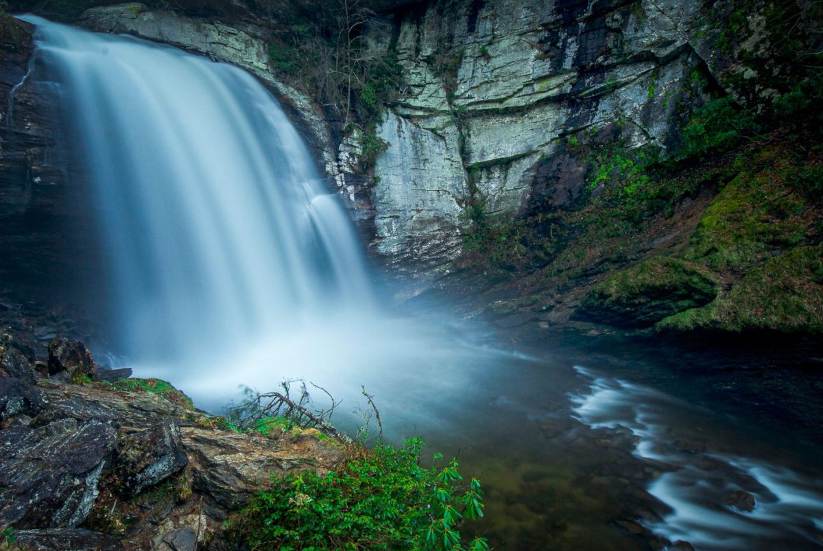 Looking Glass Falls in Brevard North Carolina near Asheville with waterfall cascading over rock cliff into clear pool below