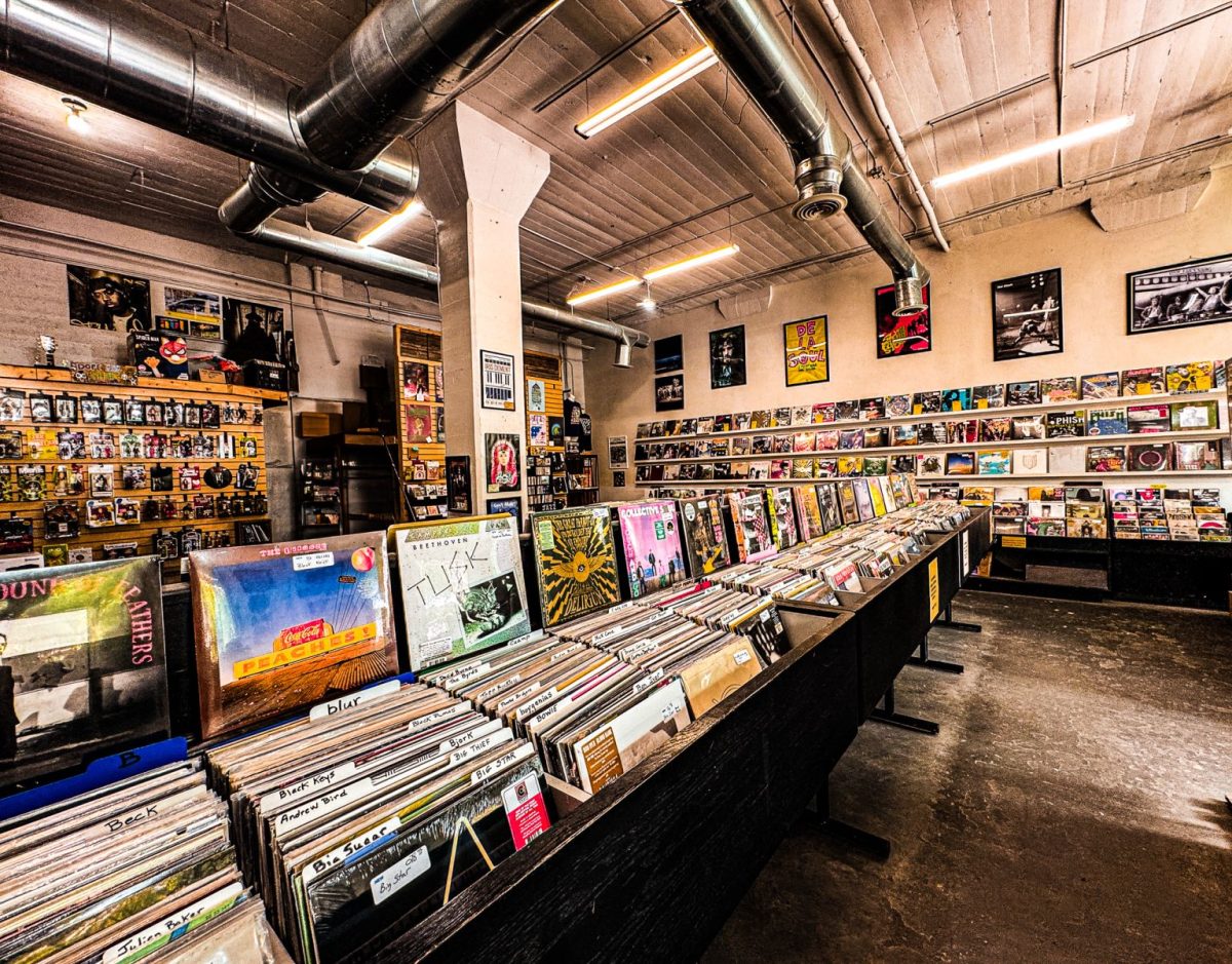 Interior of Records in the RAD in Asheville’s River Arts District featuring rows of vinyl records, industrial-style ceilings, music posters, and walls filled with albums and CDs in a creative warehouse atmosphere.