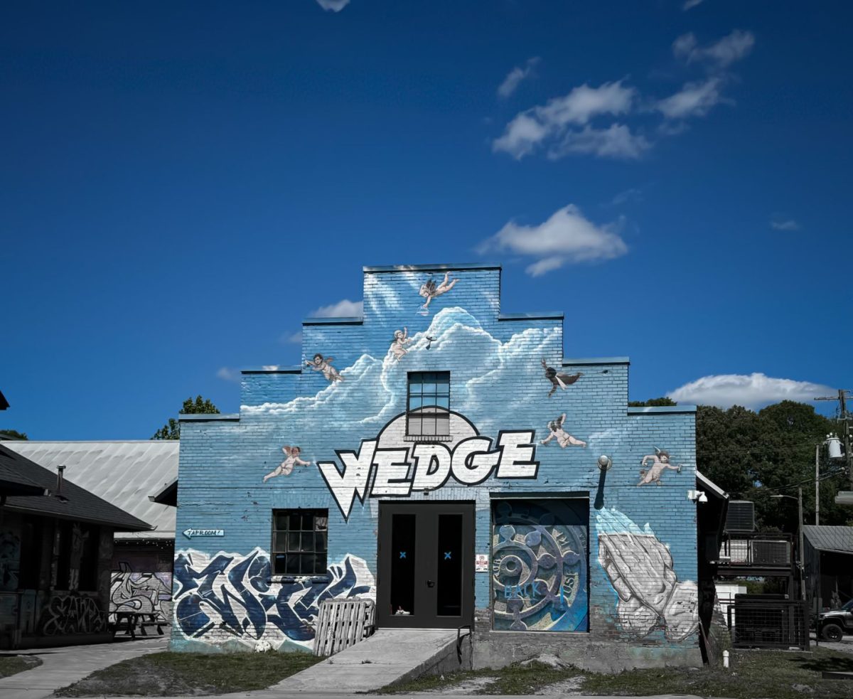 Exterior of The Wedge Brewery in Asheville’s River Arts District, featuring the iconic blue mural-covered building with the Wedge logo, street art, and surrounding creative district scenery.