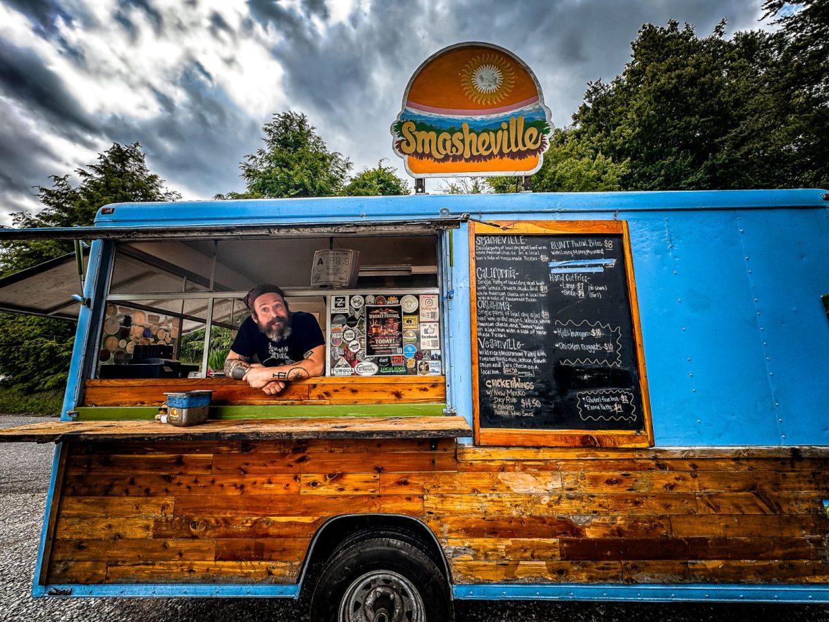 Smashville Food Truck Asheville NC - Co-Owner Graham Co-owner Graham leans out of the service window of the Smashville food truck in Asheville, NC. Known for its handcrafted smash burgers, hand-ground beef, and meticulously prepared fries, Smashville has been a local favorite for more than five years.
