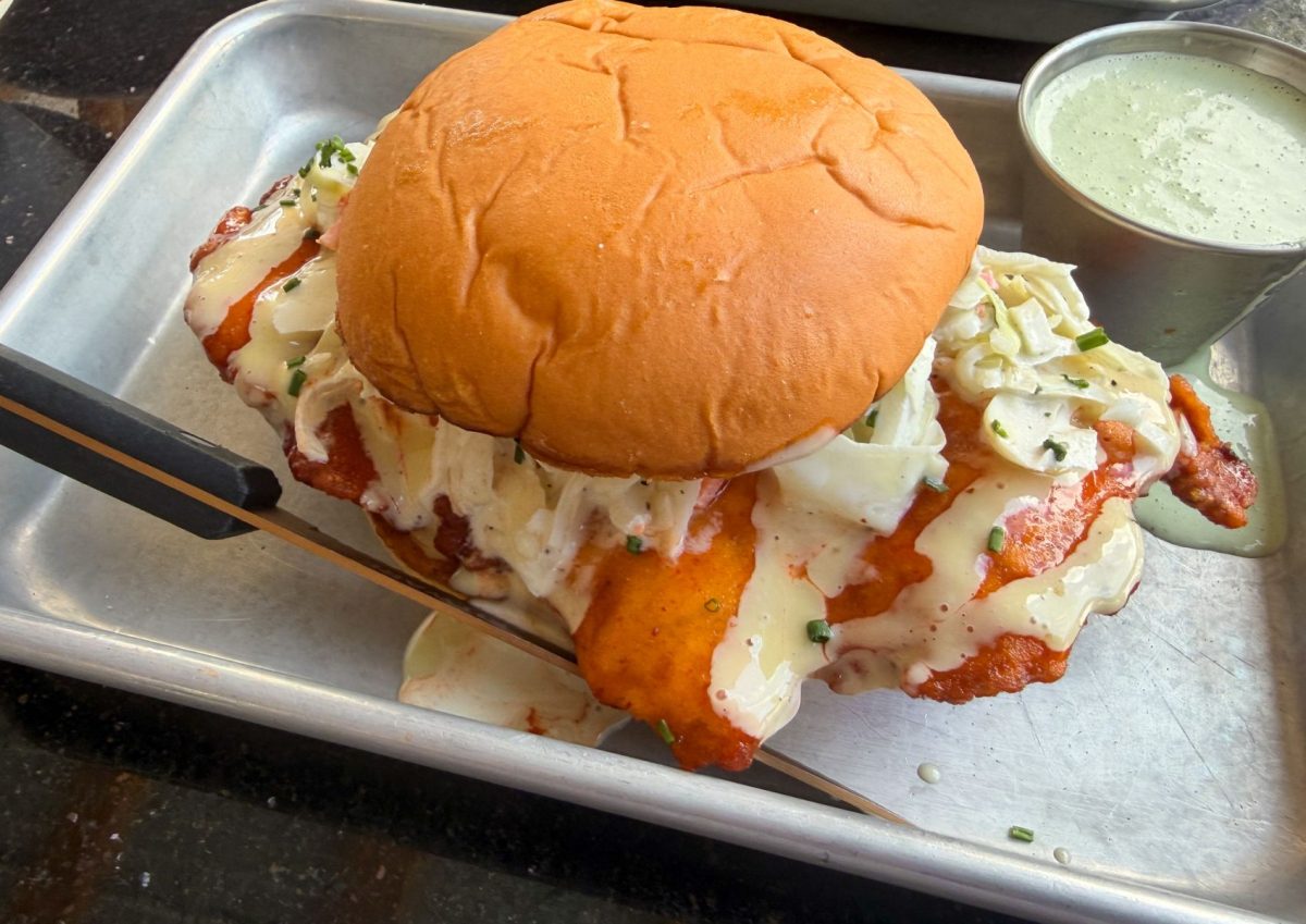 Close-up of Hail Mary's fried chicken sandwich in West Asheville, featuring crispy fried chicken topped with creamy slaw and sauce on a toasted brioche bun.