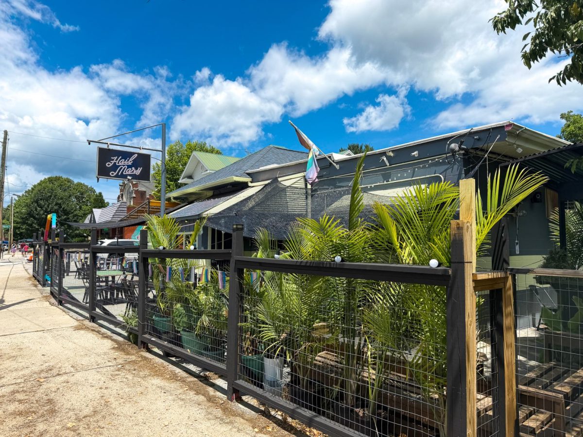 Exterior of Hail Mary restaurant in West Asheville, North Carolina, featuring its street-facing patio, tropical landscaping, and Haywood Road location under a bright blue sky.
