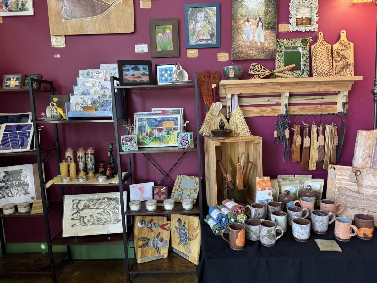 A colorful display of handcrafted artwork, pottery, wooden kitchen boards, greeting cards, candles, mugs, and artisan gifts created by local makers inside The BoBo Market in downtown Marshall, North Carolina.