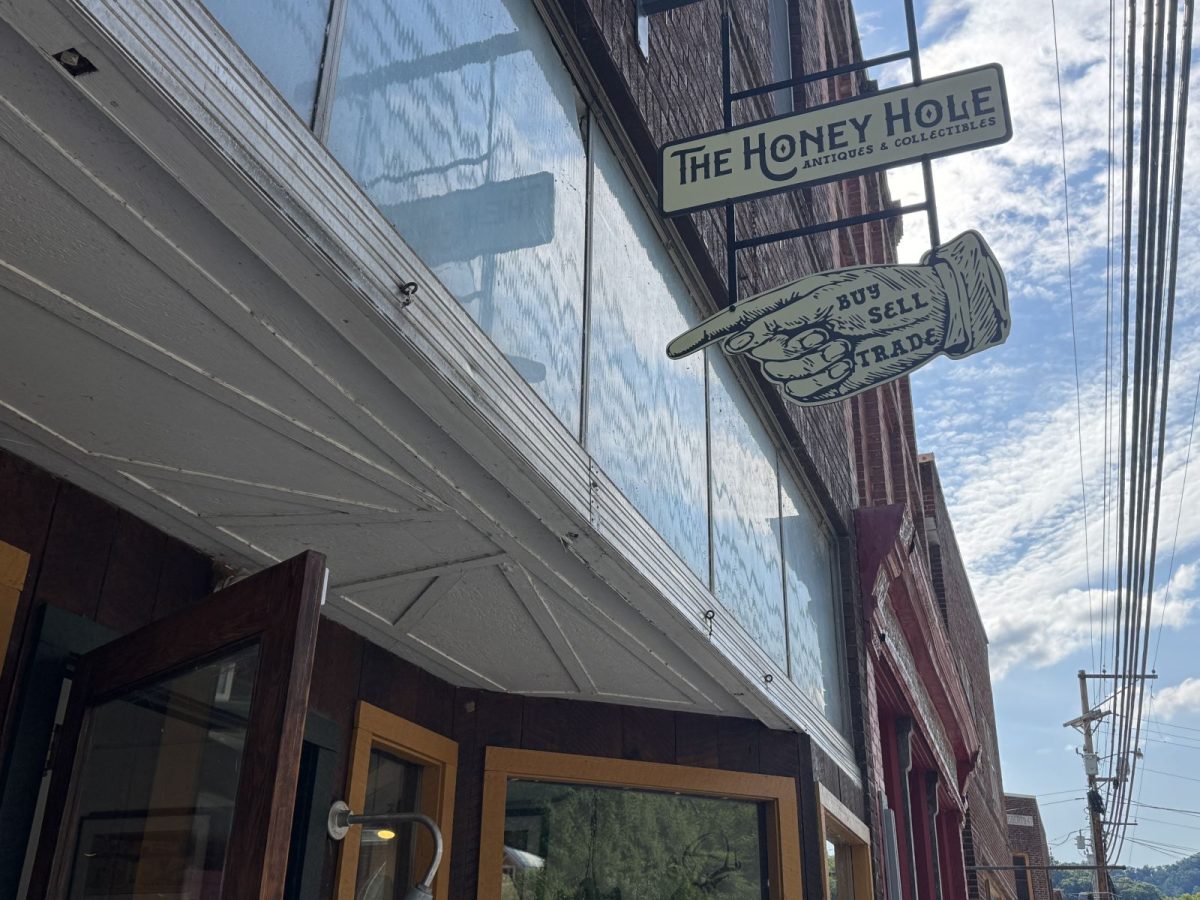 The Honey Hole storefront in downtown Marshall, North Carolina, featuring its vintage hanging sign and distinctive "Buy, Sell, Trade" pointing hand sign outside the popular antiques and collectibles shop.