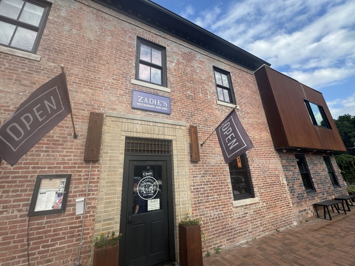 Exterior of Zadie's Restaurant and Bar in downtown Marshall, North Carolina, featuring a beautifully restored historic brick building with welcoming entrance and open flags.