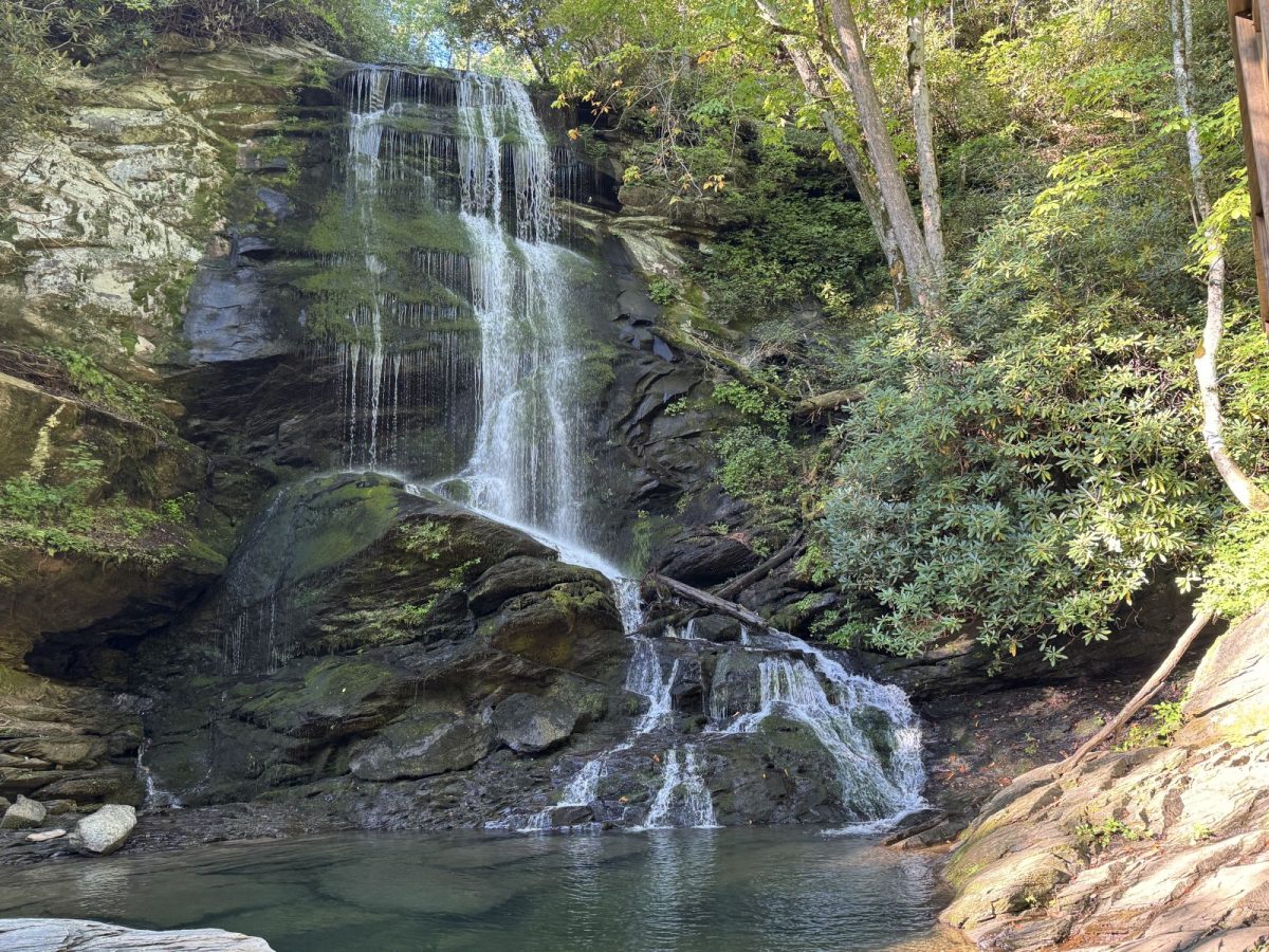 Upper Catawba Falls cascades over moss-covered rock ledges into a clear pool, surrounded by lush forest in the Pisgah National Forest near Old Fort, North Carolina.