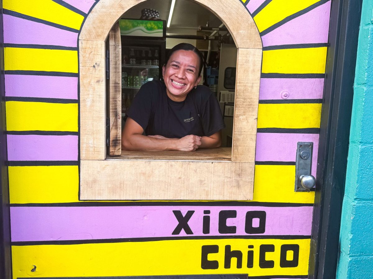Smiling Xico team member at the colorful Xico Chico taqueria window in Asheville, NC.