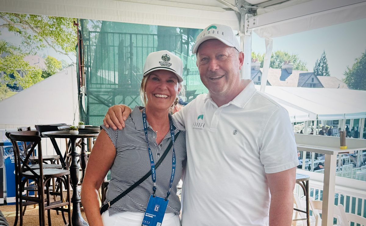 Two smiling Yonder Luxury Vacation Rentals representatives pose together in the hospitality tent at the 2026 Biltmore Championship Asheville PGA TOUR event.
